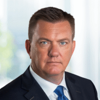 Paul Smith a man wearing a suit and tie smiling and looking at the camera